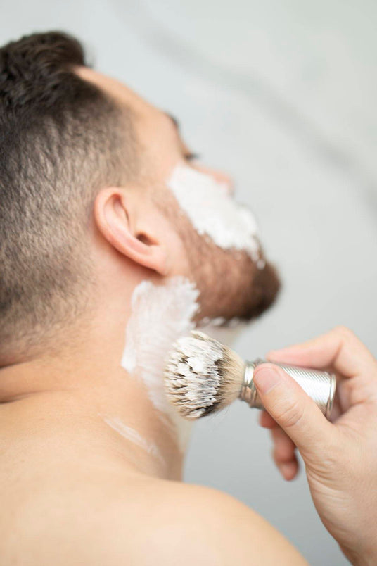 Mann som påfører barberskum med barberkost