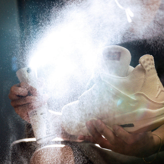 Impregnering av joggesko ved å spraye på impregnering.